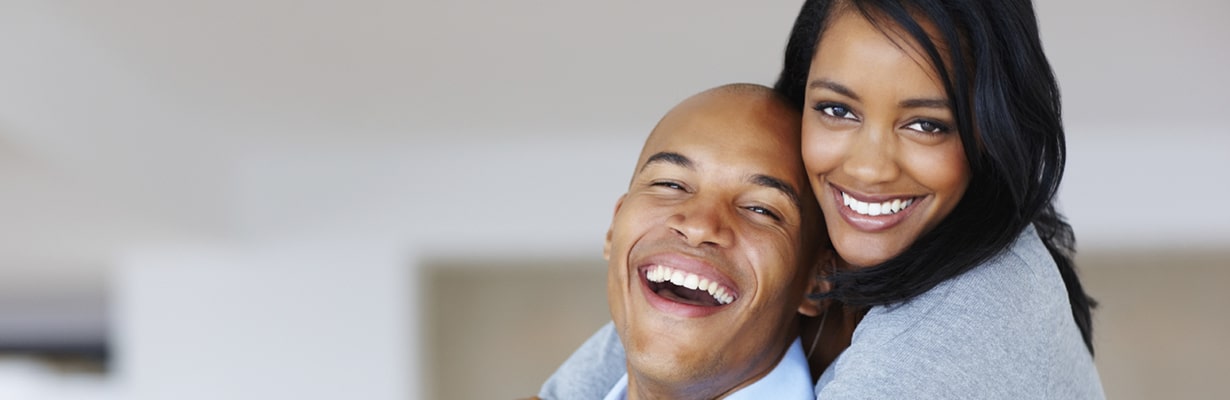 A man and a woman smiling after receiving professional cosmetic & dermatology services at Aglow Dermatology in Manhattan.