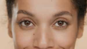 close up of brunette good looking African American woman looking at the camera with a nonsurgical eyelid lift