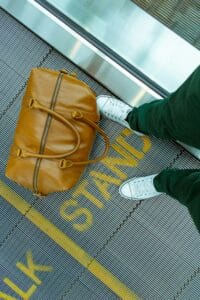 skni care for travel represented by a duffle bag on a moving sidewalk