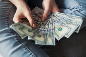 Hands holding cash to depict Does Insuracne Cover Dermatology