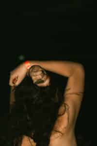 body focused repetitive behavior as depicted by the back of the head of a woman with long dark hair with hair wrapped in her fist