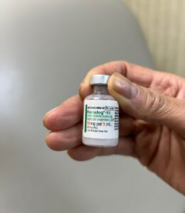 steroid injections for hair loss as depicted by a hand holding a bottle of kenalog