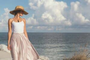 sunscreen for melasma as depicted by woman wearing wide brim sun hat on the beach