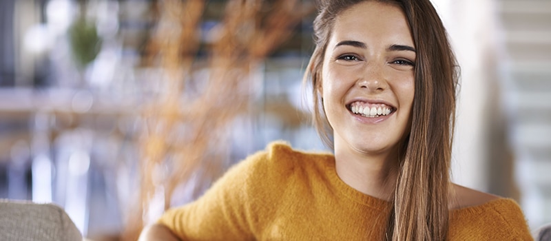 A woman with clear skin smiling confidently after receiving effective acne treatment in NYC from Aglow Dermatology.