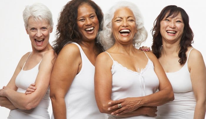 Skin of Color Aglow dermatology new york city An image of women of varying skin tones shown smiling and laughing together.