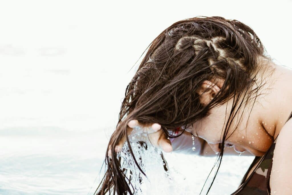 dermatologist recommended shampoo for dandruff as depicted by woman washing hair