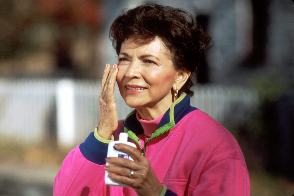 Hydroquinone for melasma as depicted by a older woman apply sunscreen to her face