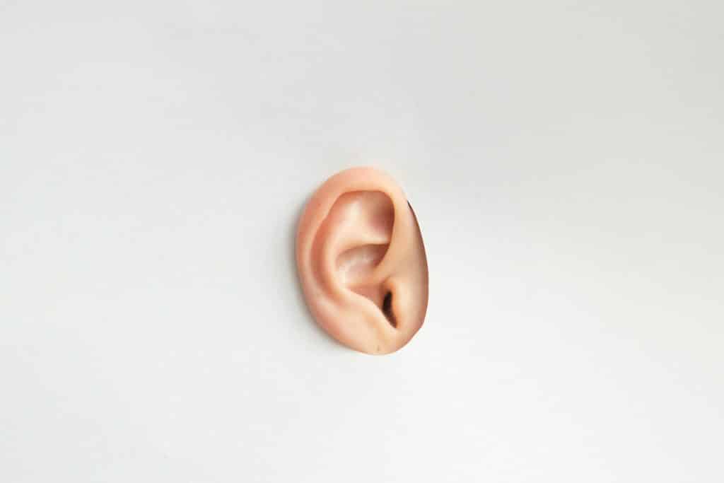 laser ear hair removal as depicted by an ear through a cut out of paper